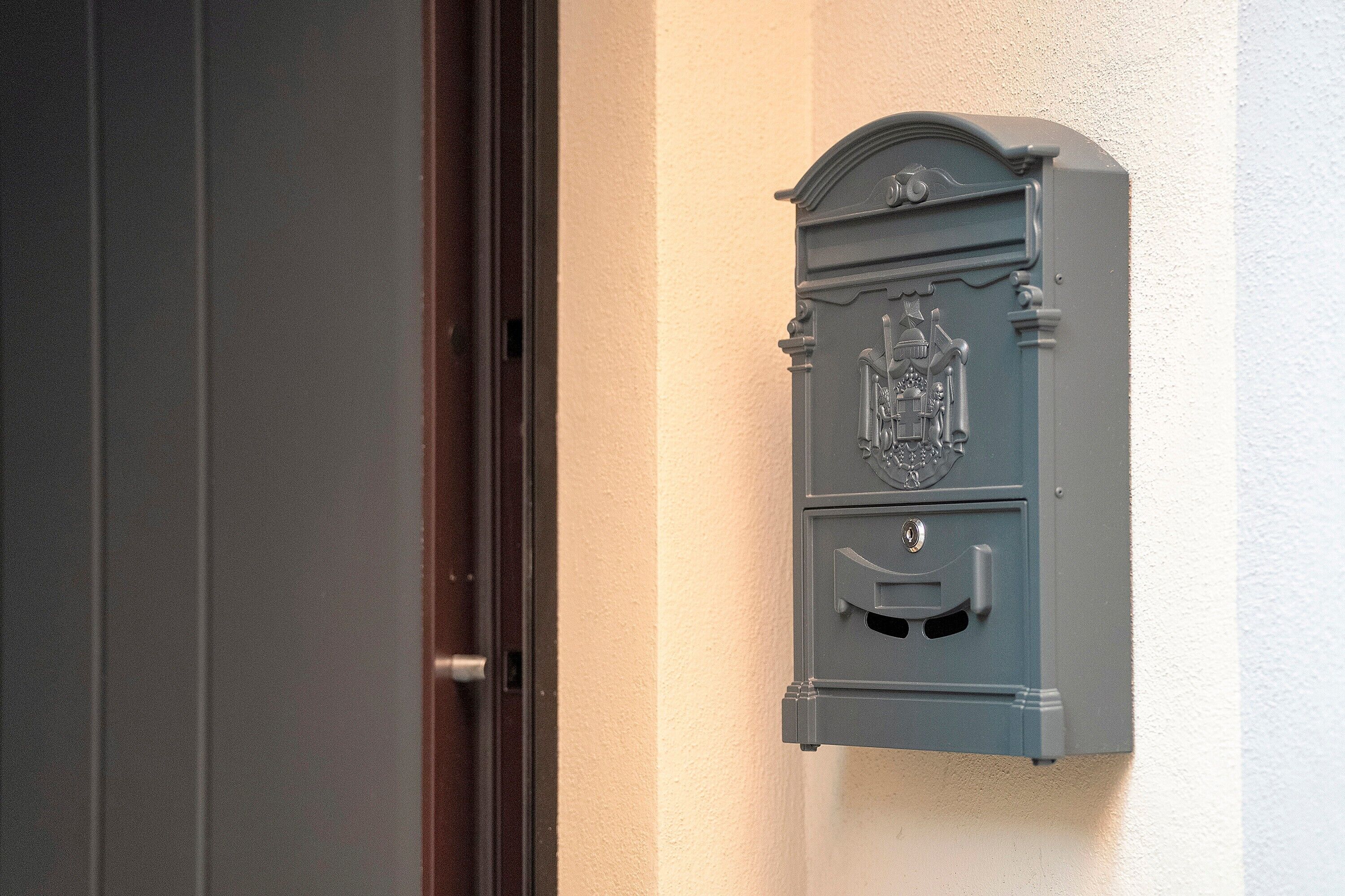 Une porte avec une boîte aux lettres fixée au mur à côté.