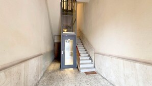 A narrow hallway with a door and a staircase. - Henry House (Lavagna)