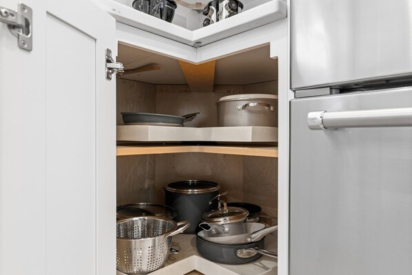 A kitchen with a built-in refrigerator, a wooden shelf, and various pots and pans. - La Oasis: Entire Luxury SFH w 5 BR/3 BA near BOS (Everett)
