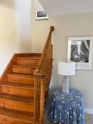 Eine Holztreppe mit einer weißen Wand und einem gerahmten Foto darüber.