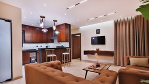 A modern living room with a sofa, a coffee table, and a TV mounted on the wall.