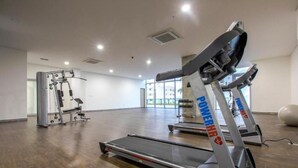 Ett gym med löpband, styrketräningsmaskiner och en stor träningsboll.
