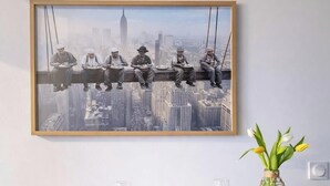 A framed photograph of construction workers on a high-rise building with a cityscape background. - L'Instant Renouveau - Park & animals (Le Mans)