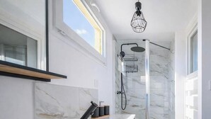 A modern bathroom with a shower, marble walls, and a skylight. - L'Instant Renouveau - Park & animals (Le Mans)