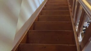 A wooden staircase with a handrail, a wall-mounted light fixture, and a door at the bottom. - Mersea standard apt - cosy holidays in Kourouta (Kourouta)