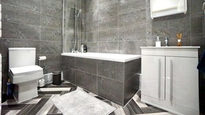 Un baño moderno con ducha, inodoro y tocador.