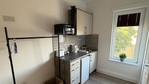 Eine kleine Küche mit Mikrowelle, Toaster, Spüle und Schränken.