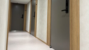 Un couloir avec des portes numérotées 202 et 204, des boiseries et un plancher de couleur claire.