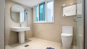 Une salle de bain moderne équipée d’un lavabo, de toilettes et d’une douche.