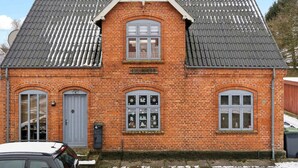 A red brick building with a gabled roof, a central entrance, and a mailbox. - 4 Star Holiday Home in Oksbol (Oksbol)