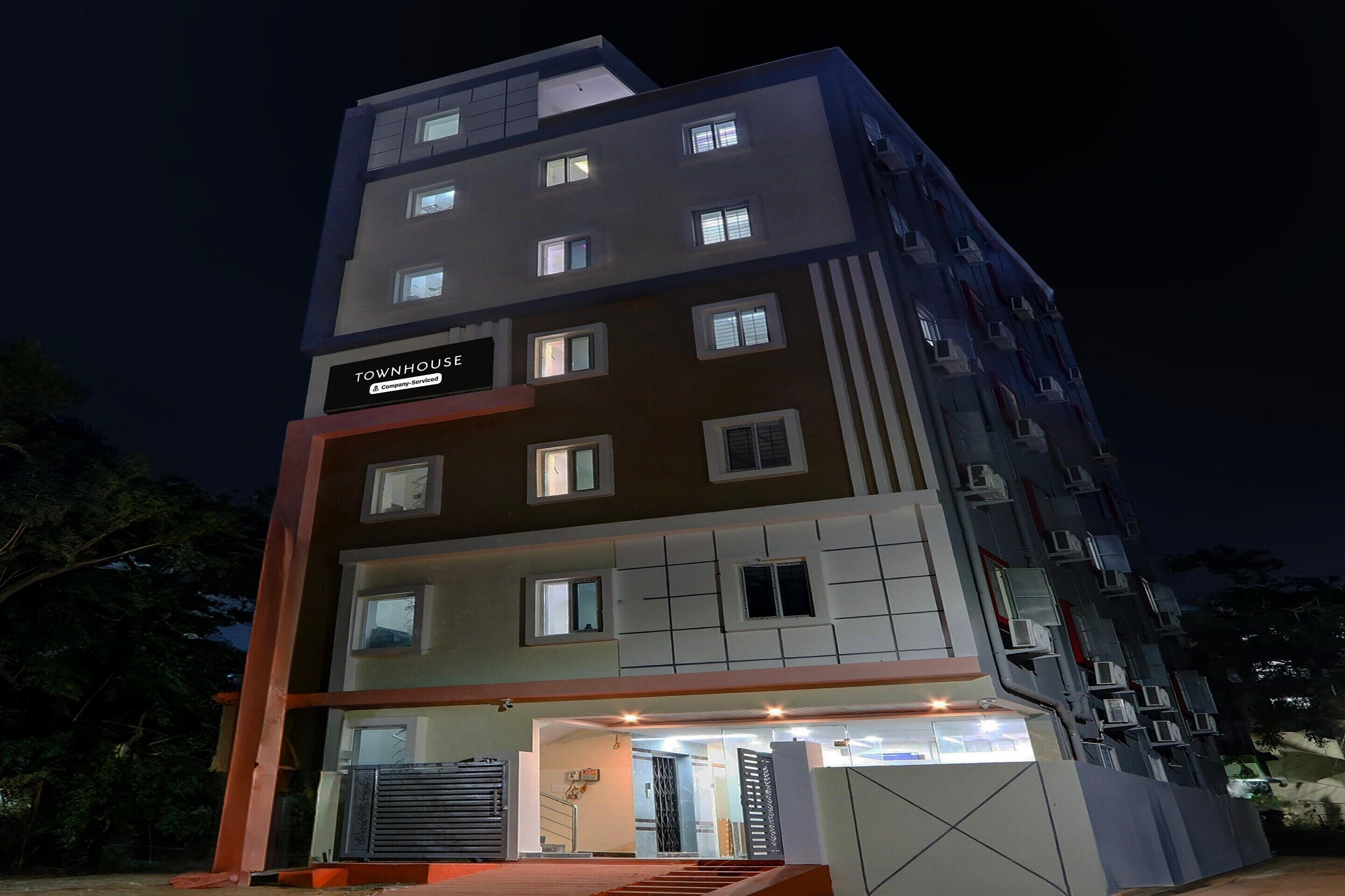A multi-story building with a sign reading "TOWNHOUSE" and "Company Services."