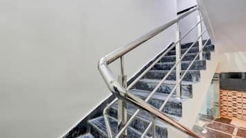 Un escalier moderne avec une rampe en métal et des marches en marbre.