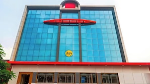 Un bâtiment doté d’une façade bleue en verre très visible, d’un auvent rouge et d’un logo circulaire jaune.