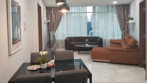 Een moderne woonkamer met een bank, een salontafel en een eettafel met stoelen.
