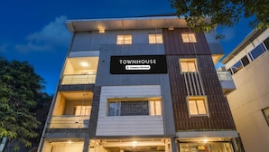 En bygning med flere etager, med et skilt, der viser 'TOWNHOUSE Company Serviced'.