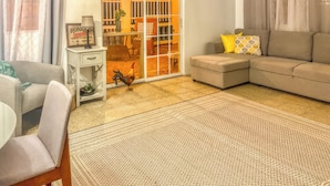 A living room with a sofa, a chair, a small table, and a decorative rooster. - Casa Nube (Caguas)