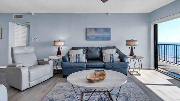 A living room with a sofa, a recliner, a coffee table, and a ceiling fan. - Ocean Sands 2-602 (Madeira Beach)