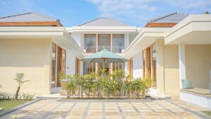 A modern house with a central patio, a covered seating area, and a symmetrical design. - Dolphin 2 – Deluxe Double Room in New Villa on Lovina Beach (Buleleng)