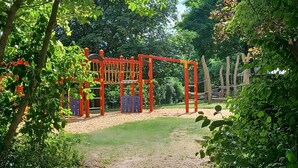 A playground with climbing structures and a sandy ground.