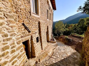 Un bâtiment en pierre avec un étroit sentier menant à un point de vue sur la montagne.