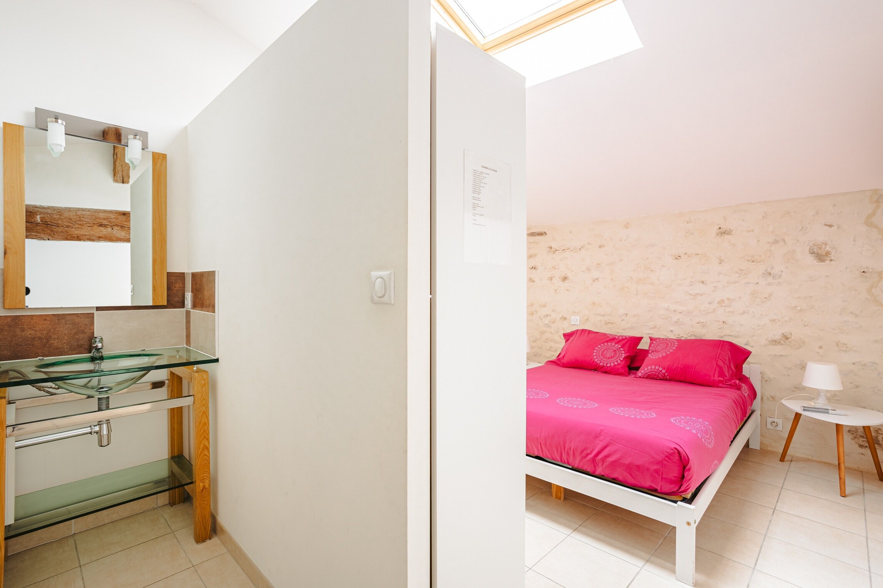 Un dormitorio con una cama, una mesita de noche y un mueble auxiliar.