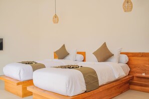 Una cama doble con cabecera de madera, dos mesitas de noche y dos lámparas colgantes.