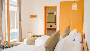 Habitación de hotel con dos camas, un armario de madera, un espejo y vista al mar.