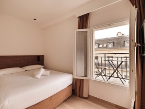 Een hotelkamer met een bed, een raam en uitzicht op de omgeving.
