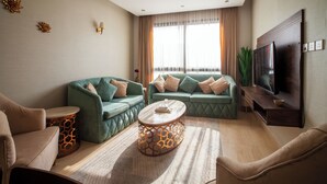 A modern living room with two green sofas, a round coffee table, and a flat-screen TV. - Darent Royal Threebedroom Al Malqa (Riyadh)