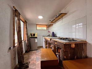 A compact kitchen with a refrigerator, a microwave, and a gas stove. - Oceana Suites San San José de Maipo II (San Alfonso)