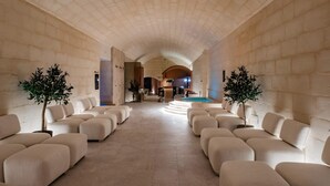 Un salón amplio con techo abovedado y una zona de piscina al fondo.