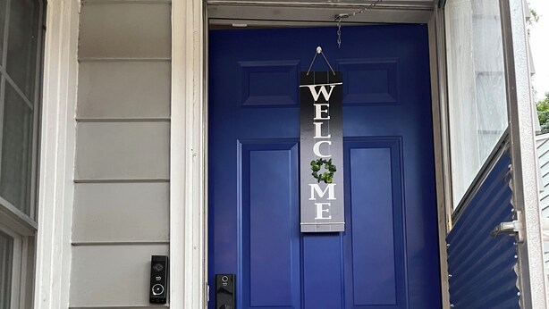 A blue door with a 'WELCOME' sign and a small wreath. - Fully Furnished Corporate Rental - 2 Kitchens + Private Suite - 30+ Day Stays (Barberton)