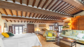 Une pièce spacieuse avec un grand lit, un canapé, une table basse et un plafond en bois.