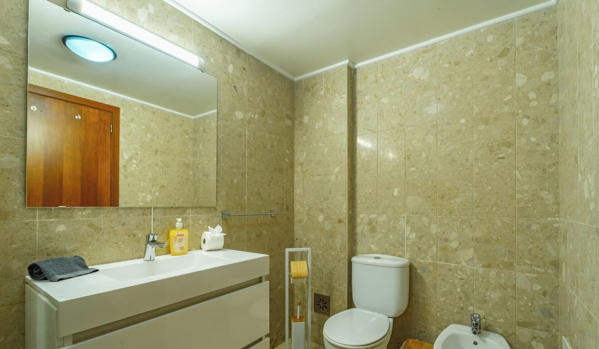 Ein Badezimmer mit Waschbecken, Toilette, Bidet und Spiegel.