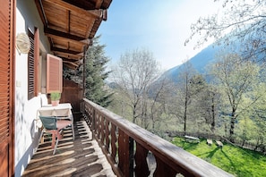 A wooden balcony with a table and chairs, overlooking a mountainous landscape. - Room 'Mayrhof Rosmarinzimmer' with Mountain View, Shared Garden and Wi-Fi (San Pancrazio)