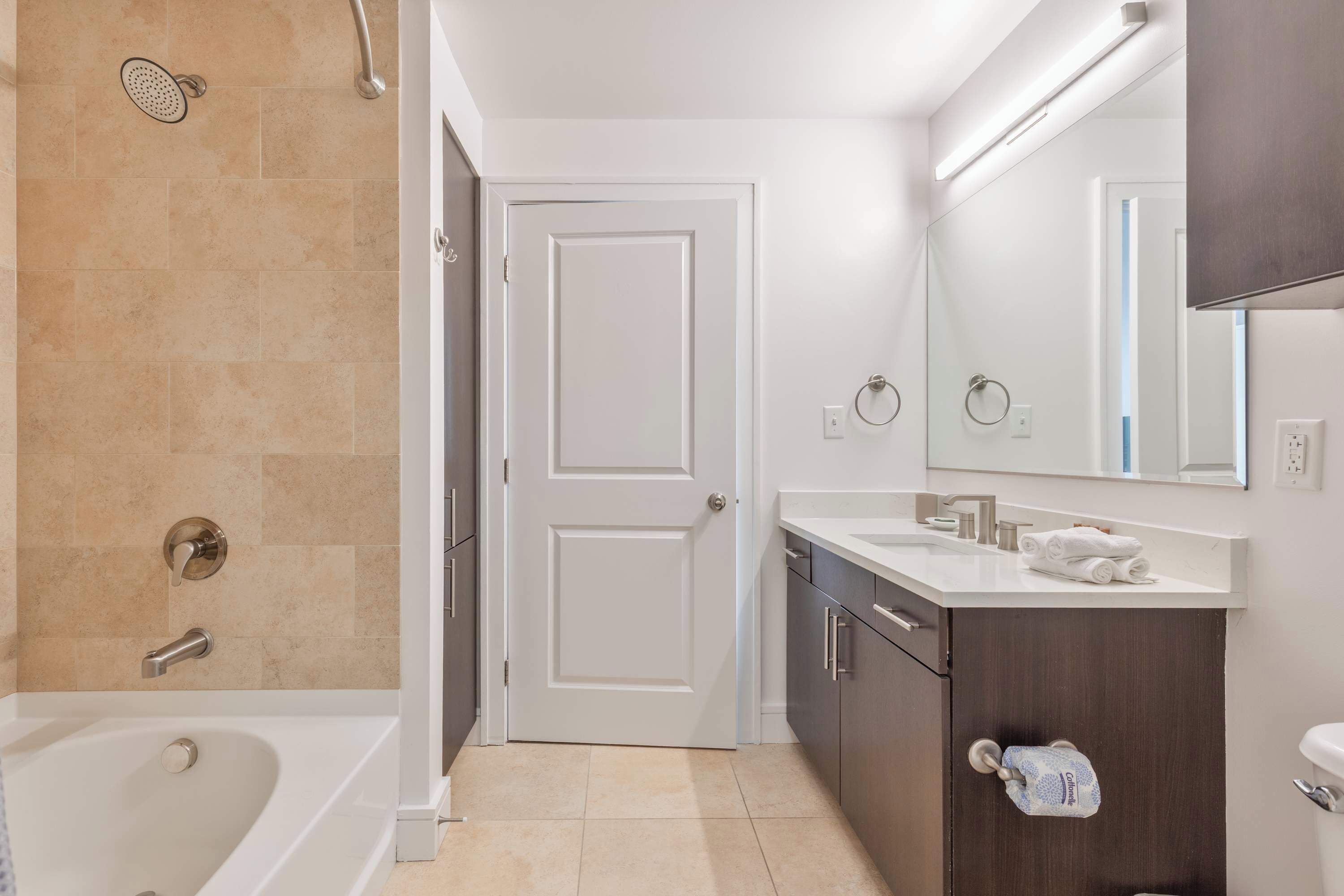 Une salle de bain moderne équipée d’une baignoire, d’une douche, de toilettes, d’un lavabo et d’un miroir.