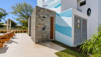 Un bâtiment doté d’une façade en pierre, d’une fresque représentant une vague bleue et d’un panneau indiquant le chiffre « 3 ».