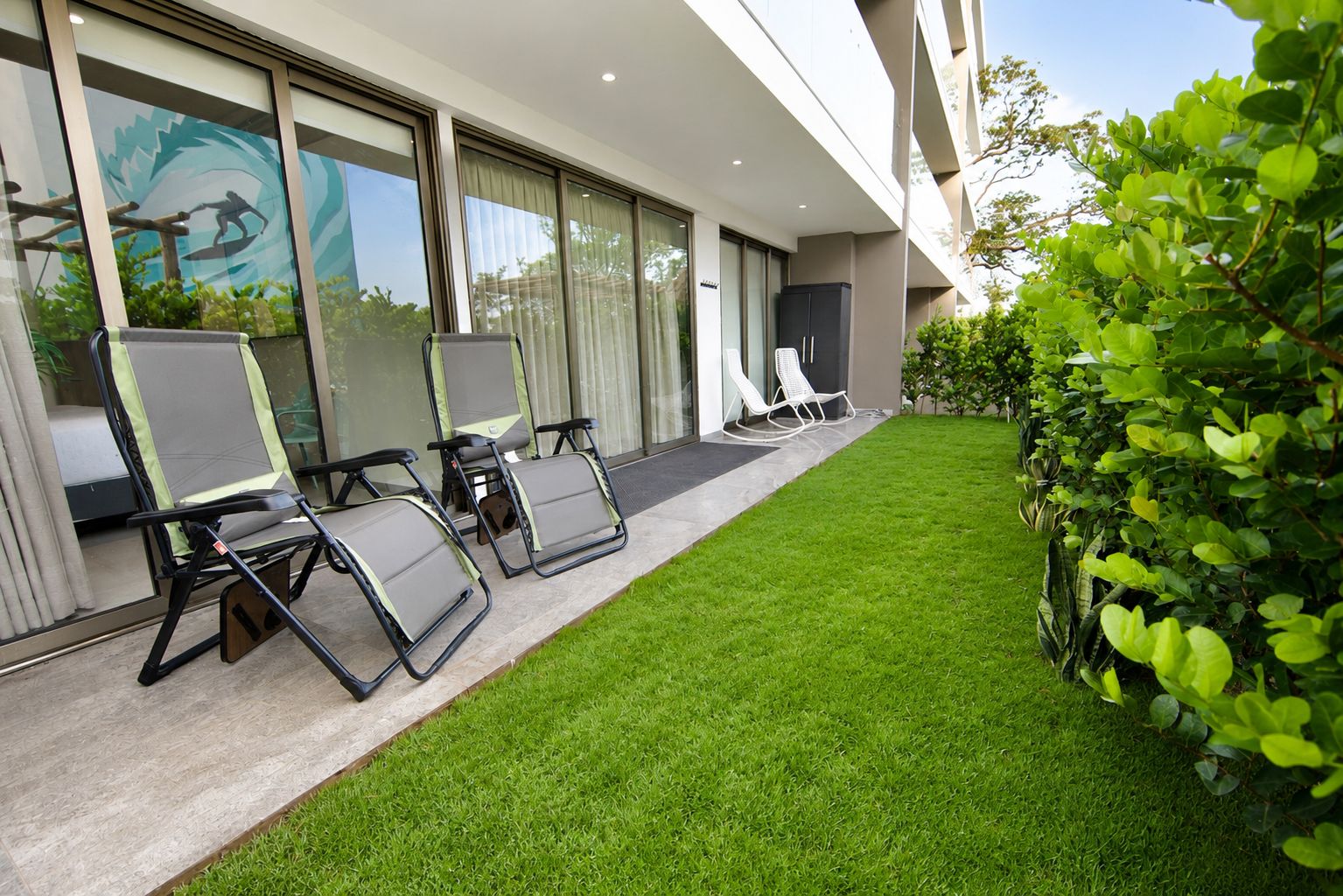 A modern building with a well-maintained lawn and outdoor seating area.
