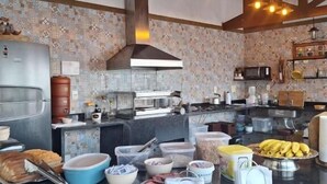 Une cuisine dotée d’un îlot central, de poutres en bois et d’un crédence décorée.