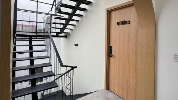 Un interior moderno con una escalera, una puerta de madera y un tragaluz.