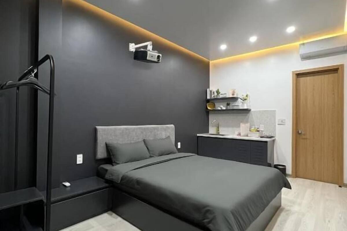 Un dormitorio moderno con cama, escritorio y armario.