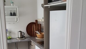 Una cocina compacta con microondas, horno y una pequeña encimera.