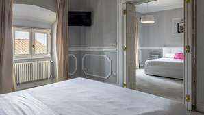 A bedroom with a bed, a television, a radiator, and a window with curtains. - Brunelleschi Elegant by MMega (Florence)