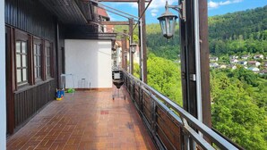 A balcony with a brick floor, wooden railings, and a view of a green landscape. - Boardinghaus Wildberg - Fitter's room near Nagold & Calw (Wildberg)