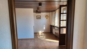 An open hallway with wooden flooring, a door frame, and a small table with a cushion. - Boardinghaus Wildberg - Fitter's room near Nagold & Calw (Wildberg)