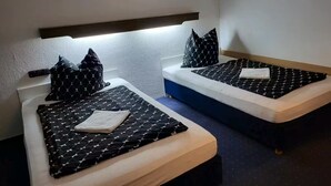 Two single beds with headboards, a small wall decoration, and a nightlight. - Boardinghaus Wildberg - Fitter's room near Nagold & Calw (Wildberg)