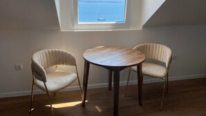 Ein Zimmer mit Oberlicht, zwei Stühlen und einem runden Tisch.