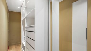Ein schmaler Flur mit einem weißen Schrank und Regale.