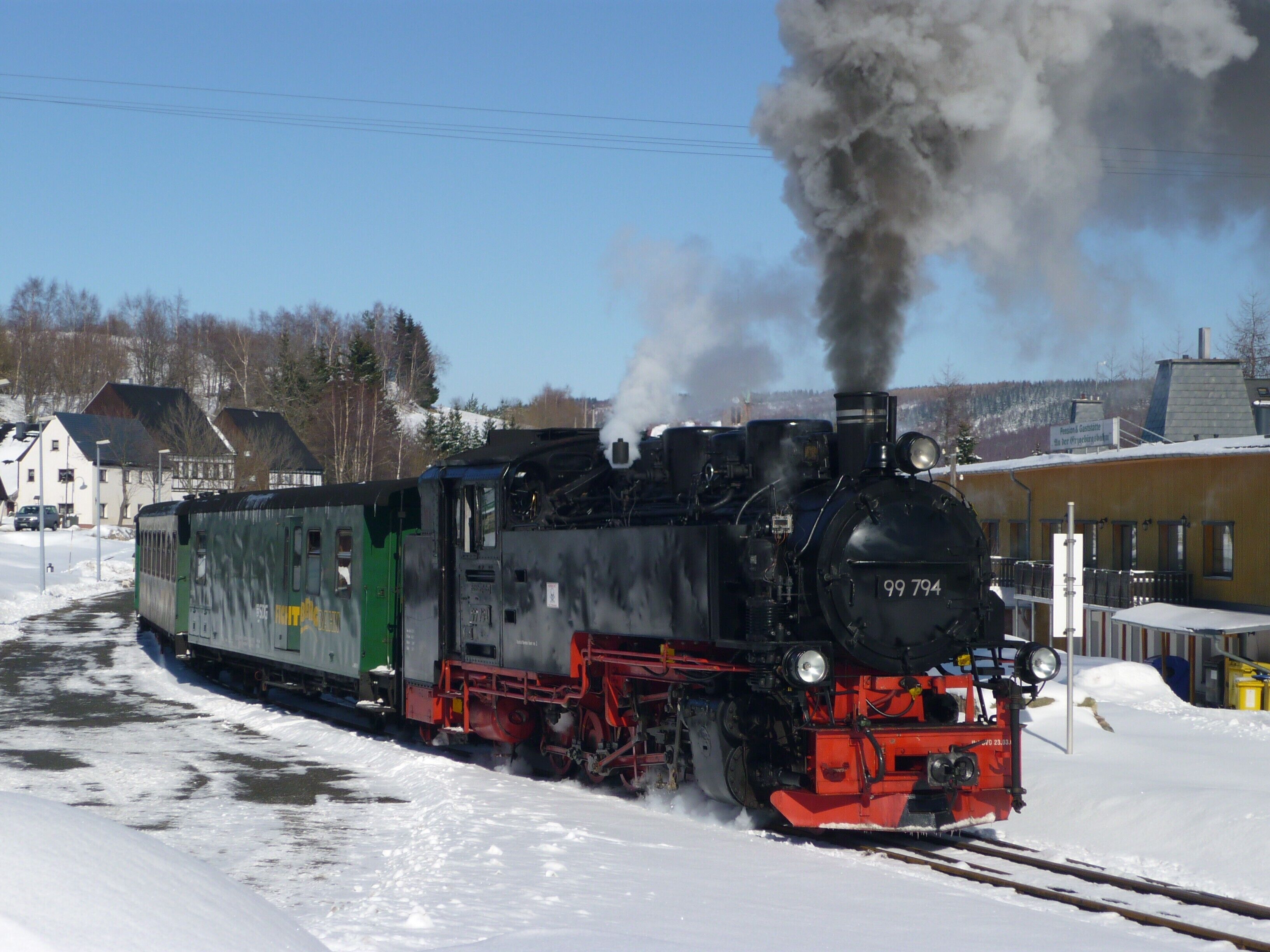 A steam locomotive with the number 99 794 on a snowy railway track.