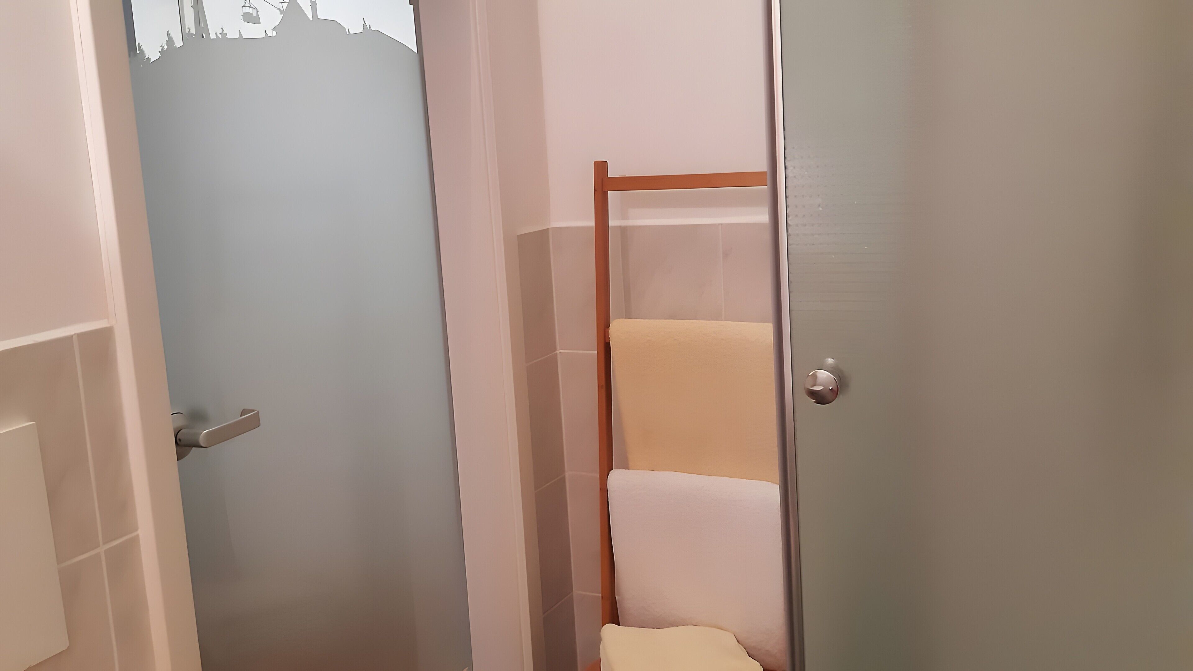A bathroom with a shower, a toilet, and a sink.